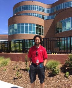 Michael Maxey, a valet and a new father, poses in front of Memorial Hospital.