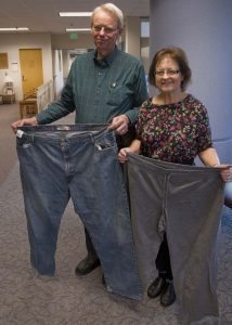 Diane and Dan Hopmann show off pants they used to wear. Dan lost 114 pounds and Diane lost 104.