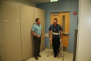 The patient begins walking with his physical therapist.