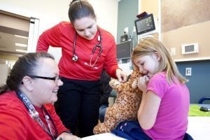 ER staff talk with a girl holding a cheta stuffed animal