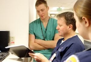 PVH Medical Unit RN Jimi Killen is shown in this photo discussing his job with shadowing first-year resident Austin Fain and UNC nursing student Julia Knox.