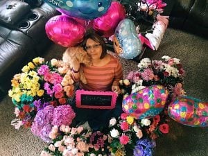 Val Sotelo, wearing a wig after chemotherapy caused her hair to fall out, is surrounded by flowers on her last day of chemotherapy treatment.