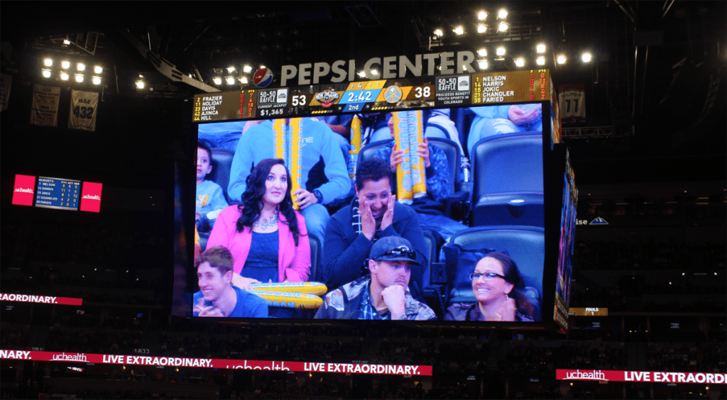 Val Sotelo, a UCHealth Memorial Hospital employee, is overwhelmed with emotion when her story is shared during a Denver Nuggets game. Sotelo was honored as part of UCHealth's Moments to Shine program.