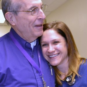 Registered nurse Gwen Crist is shown receiving a hug from volunteer Bob Allen.