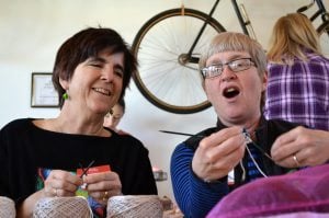 UCHealth physician Barbara Widom respiratory therapist Lori Taylor are shown working side by side on their knitted knockers at the Knit for a Cause Knit-A-Thon at Wolverine Farm Letterpress and Publick House in Fort Collins.