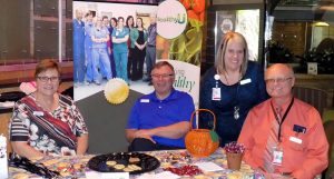 Four people are pictured at an event during a Patient Centered Care Awareness month activity.
