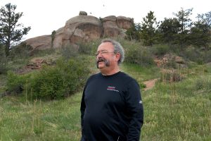 Stan Kepley stand on a trail leading up to some rocks at Kurt Goudy State Park near Cheyenne, Wyoming.