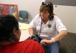 Julie Bower, paramedic for UCHealth EMS, takes the blood pressure of a women who was complaining of chest pains during EMS weekly clinic at the Larimer County Community Corrections