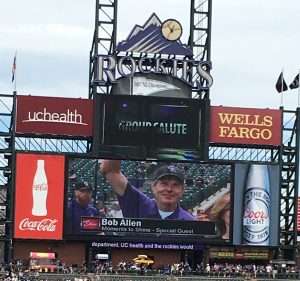 Volunteer Bob Allen is shown on the jumbotron during a Colorado Rockies baseball game.