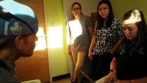 Patient Pancho Bustamante speaks with his medical providers. An interpreter also helps during the exam.