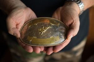 J.D. Hill holds a bull riding championship buckle