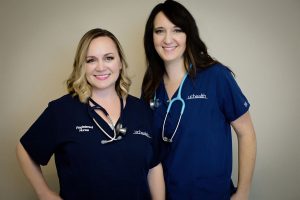Portrait of two ICU nurses in their uniforms, Jenelle Baer, left, and Janet Nelson.