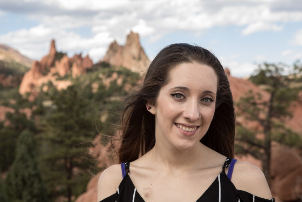 Hannah Moraski, 24, poses with red rocks behind her. She often has to have hospital treatments and gets to use virtual reality to travel virtually where she can't go in person.