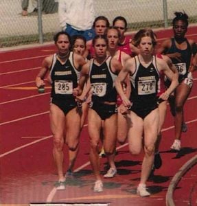 Becky was a competitive runner in high school and college. Here she runs with a group of runners on a field. She's in the lead.