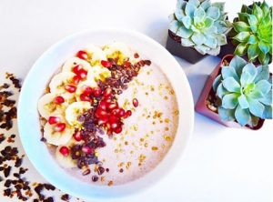 A bowl filled with bananas and coconut with tropical plants nearby. Photo by Nikole Rachelson.