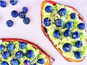Toasted sweet potato with avocados blueberry and chia seeds make for a colorful, healthy breakfast.