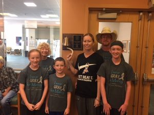 Marcy Brossman rings a bell, signifying the last day of radiation treatment. She's joined by her family.