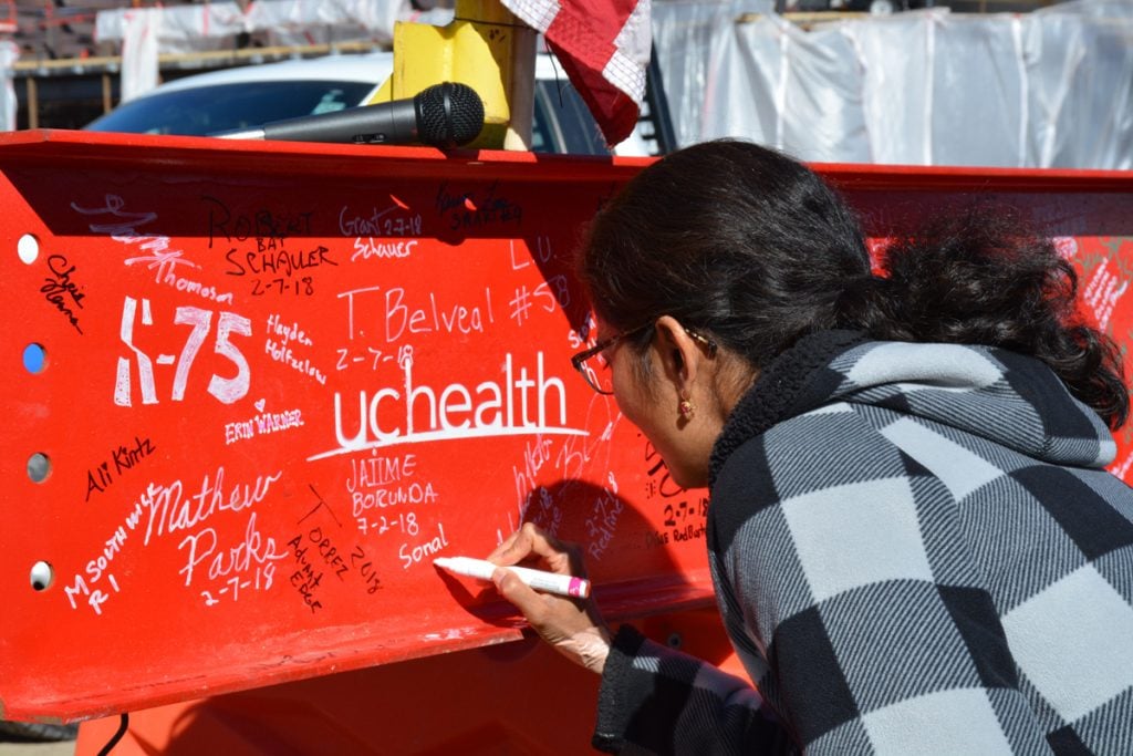 A woman signs her name to a beam placed on an expansion of Memorial Hospital North during a 'Topping Off' ceremony on Wednesday.