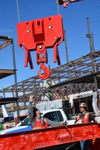Construction crews prepare to lift a beam to the top of a four-story building under construction at Memorial Hospital North.