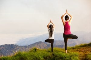 A mother and daughter strike yoga poses.