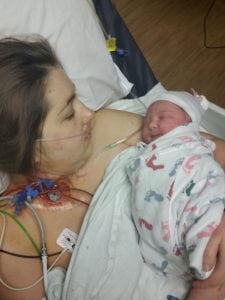 mom holding her newborn after surgery where she needed 8 units of blood because of placenta accreta.