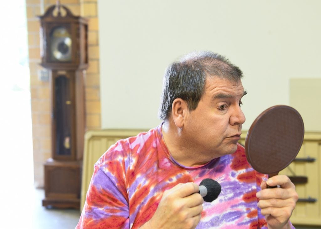 Actor Greg West puts on makeup before a play. West had heart failure and had both an LVAD and a heart transplant. 