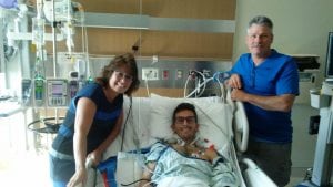 : Liver transplant recipient Richie Davidowski, with parents Kelly and Richard, in a room on the STICU shortly after Brainard and team discussed his case during rounds.
