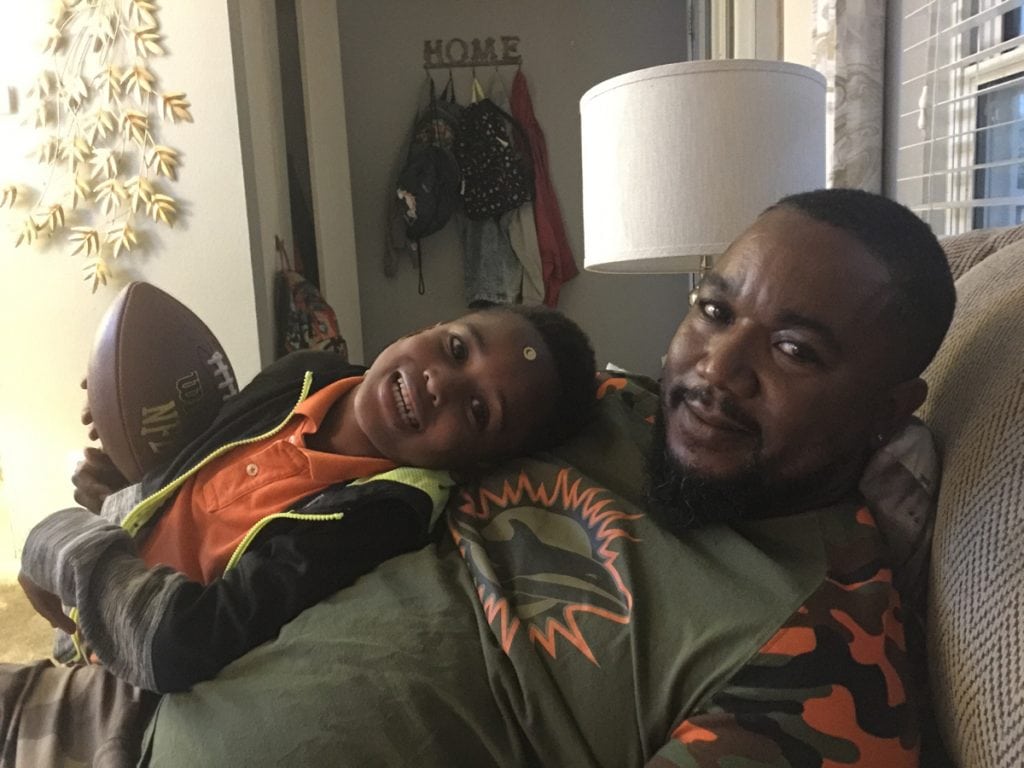 David Kenyatta cuddling with his son, DJ.