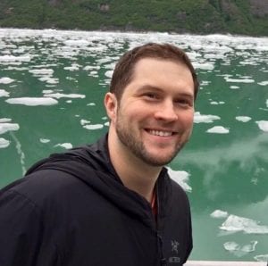Dr. Dan Pastula is an expert in a disease called acute flaccid myelitis or AFM and helped recognize it when a virus attacked a young Lakewood mom. Here he poses on a trip to a lake with icebergs floating behind him.