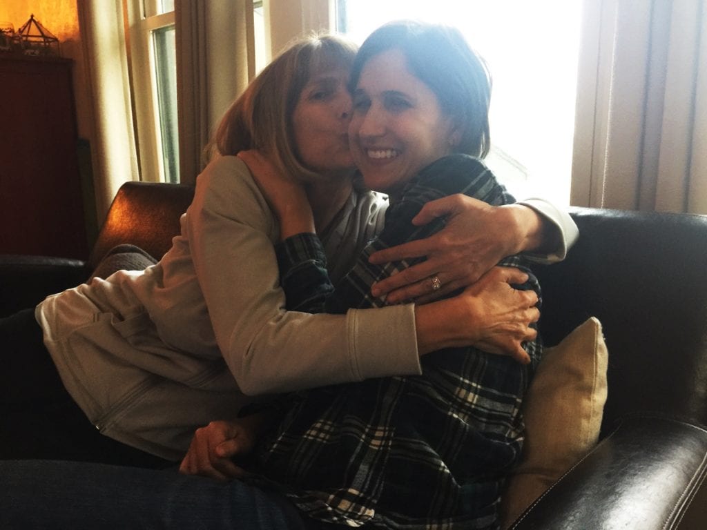 Besty Brock, left, hugs her daughter, Emily West. She's thrilled that her daughter is recovering from a rare polio-like illness caled AFM.