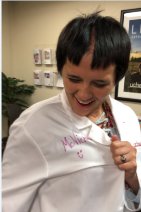 Jasmine Porr sports a white medical coat during a return visit to UCHealth Memorial Hospital Central. Her neurosurgeon, Dr. John McVicker, autographed the coat.