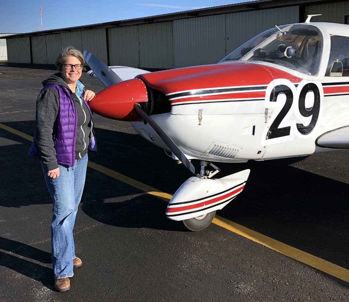 pilot stands at front of small plane