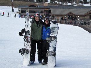 Bob Hunt and his son stand in the snow as they hold their boards.