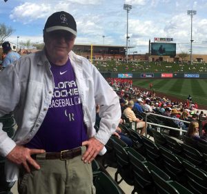 Jim in the stands of spring training wearing a Colorado Rockies Baseball shirt
