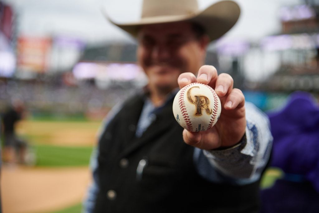Mike with a baseball branded with the Colorado Rockies logo.