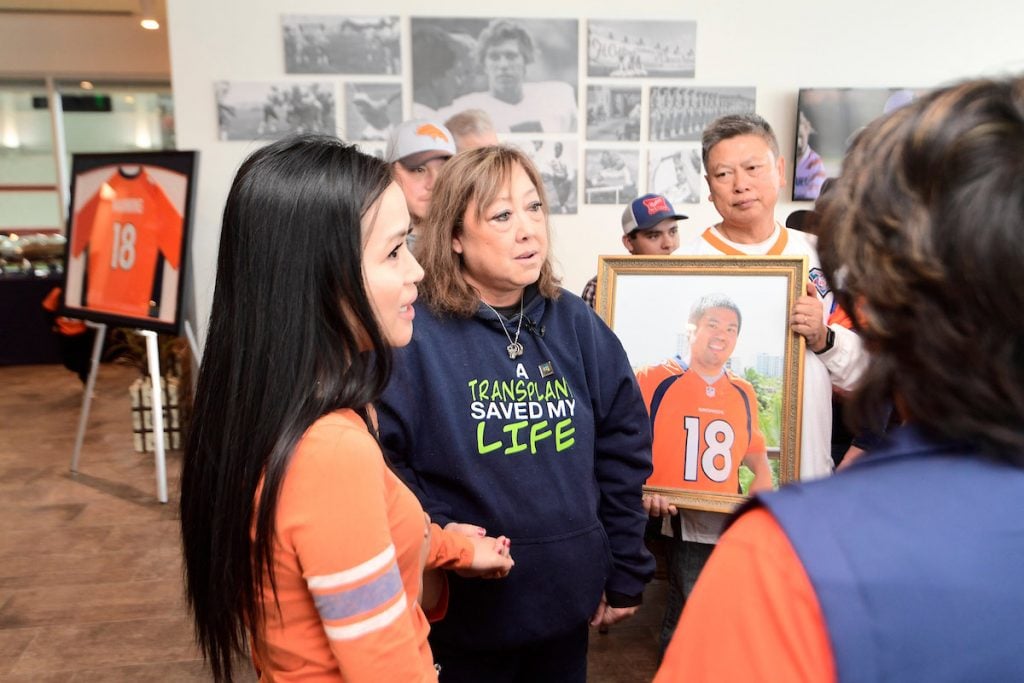Linda Regis wears a sweatshirt saying, "A transplant saved my life" while she, a transplant recipient, meets family of the donor.