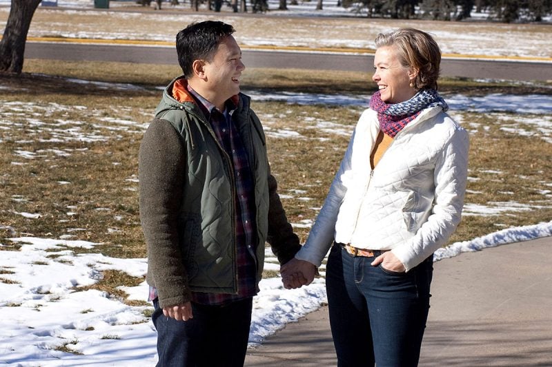 husband and wife smile at each other while hold hands in a park on a snowy day. They credit Victor being alive to the use of ECMO for acute respiratory distress syndrome that plagued Victor six years ago.