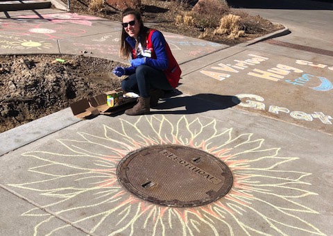 UCHealth volunteers chalk the walk outside of UCH.