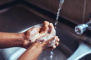 ethnic person washing hands, details which are answered in the COVID-19 FAQ.