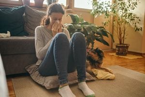 symptoms, like this women blowing her nose, is answered in this COVID-19 FAQ.
