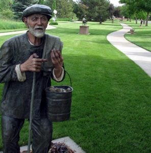 sculpture of old man carrying bucket of potatoes at a park in Colorado.