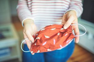 women holding a homemade mask. this coronavirus FAQ answers questions about wearing masks.