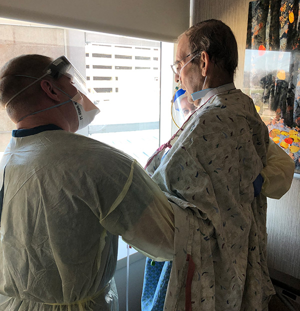 as the first convalescent plasma recipient leaves ICU, Dr. Michael Leonard waves to his family before leaving his ICU room.