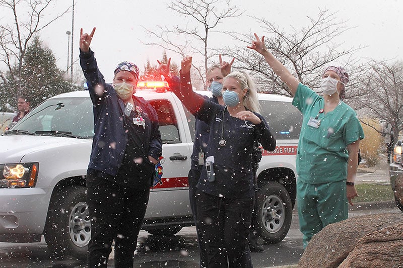 Health care workers at MCR wave to first responders parading through their hospital parking lot, one way Colorado thanks UCHealth health care workers.