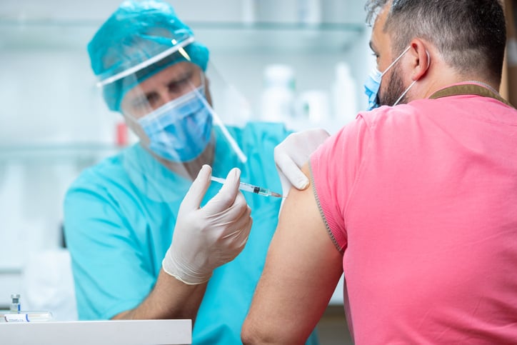 A photo of a doctor injecting a vaccine into a patient as coronavirus drug trials are underway at UCHealth.