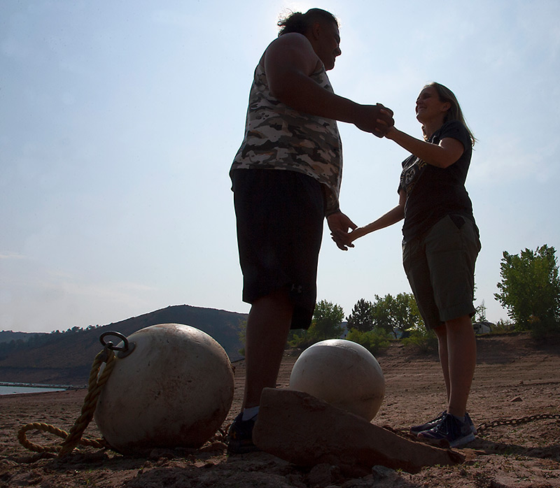Edgar, who has been recovering from a stroke, holds his wife's hands at the beach in a silhouette photo.