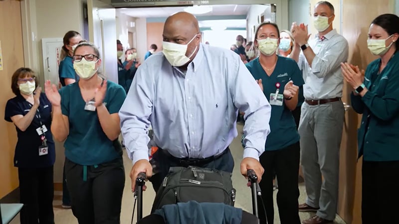 UCHealth staff celebrated as a man leaves the hospital with a walker. He is one of 2,001 UCHealth COVID survivors as of Oct. 6, 2020. 