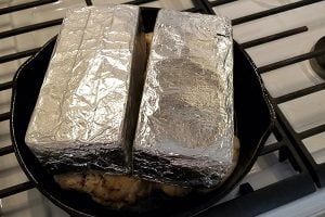 Try roasting chicken under a brick in your oven like shown here with a cast iron skillet, chicken laid flat and brings wrapped in foil on top of the chicken.