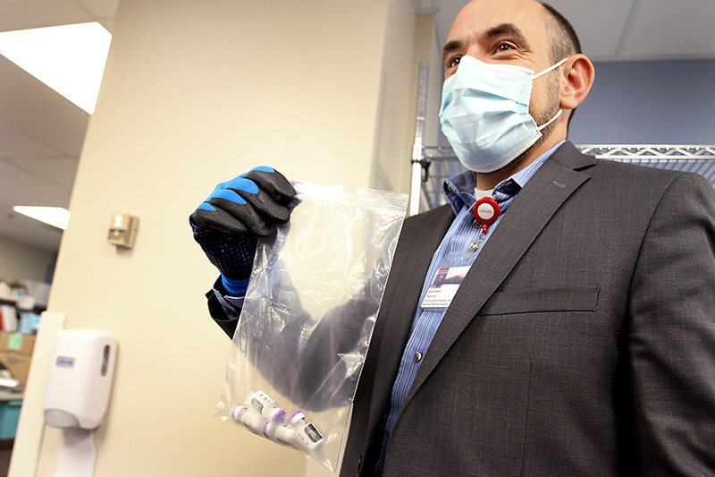Andrew Harmon, director of outpatient and retail pharmacy, for UCHealth in Northern Colorado, thaws the 4 vials (20 doses) of vaccine that will be used to vaccinate the first health care workers in Colorado on Monday morning, Dec. 14. Photo by Joel Blocker for UCHealth.