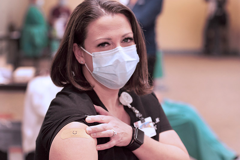 Dr. Natalie Rochester, an OB-GYN at UCHealth in Northern Colorado, gets a smiley face on the spot she got vaccinated, a request from her kindergarten-age daughter and classmates. Photo by Joel Blocker for UCHealth.